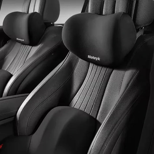 Black neck and lumbar pillows installed on a car's front seats